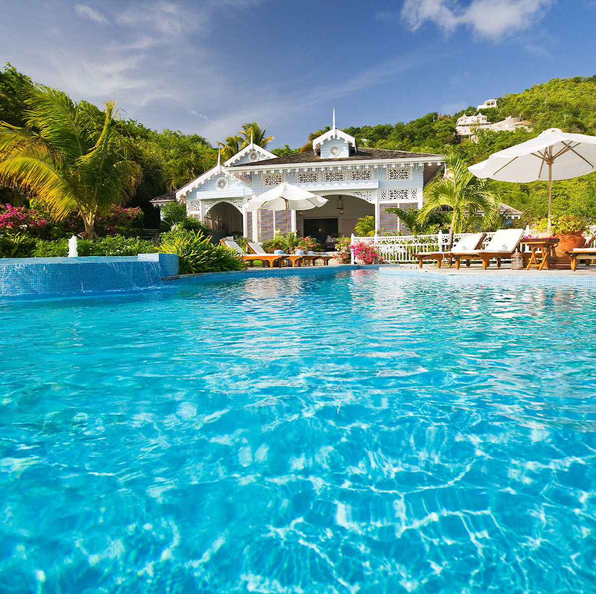 Sparlking deep blue pool in front of Traditional Caribbean Villa