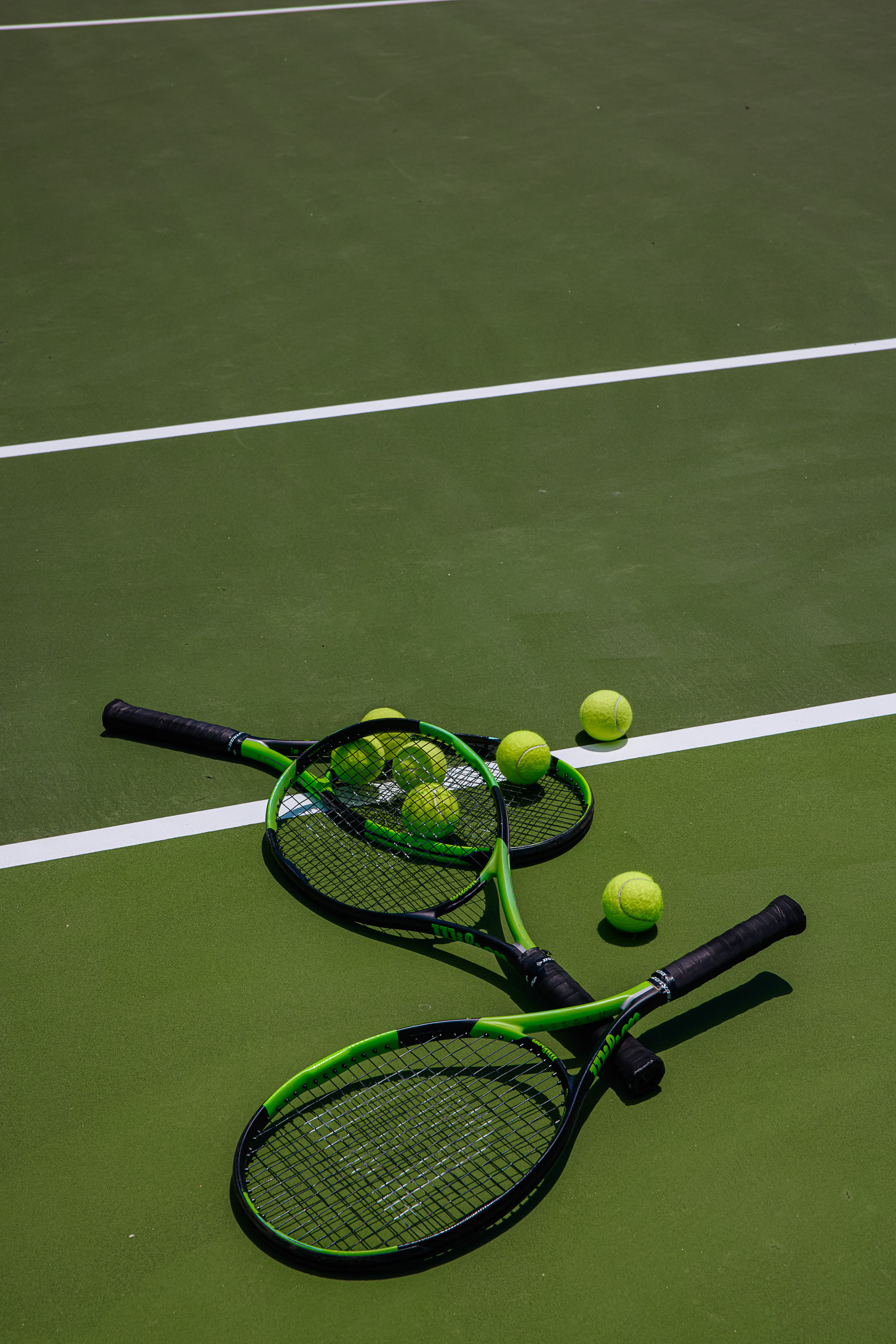 Tennis Rackets, balls on a sun drenched court